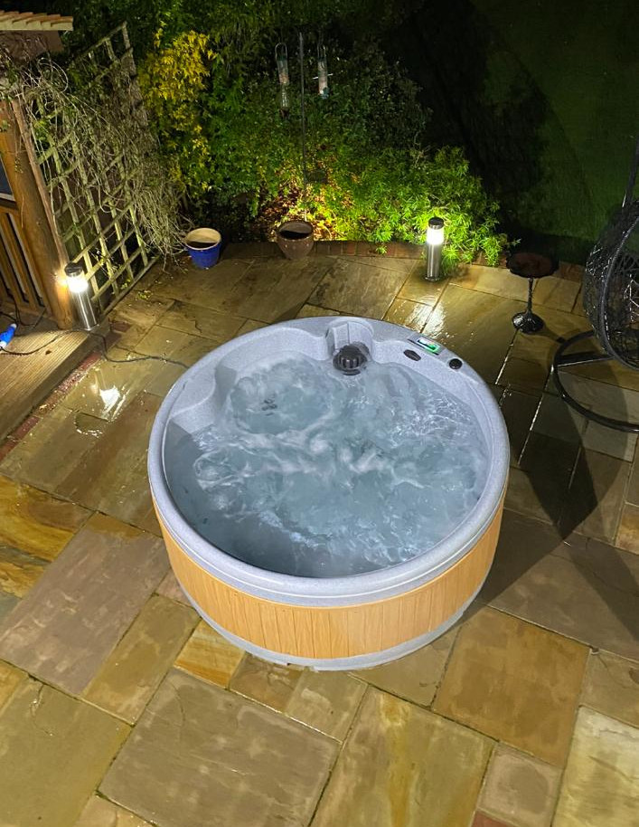 Solid hot tub with bubbles, sitting on a patio, shot from above