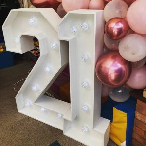 LED light-up numbers - 21 surrounded by pink balloons